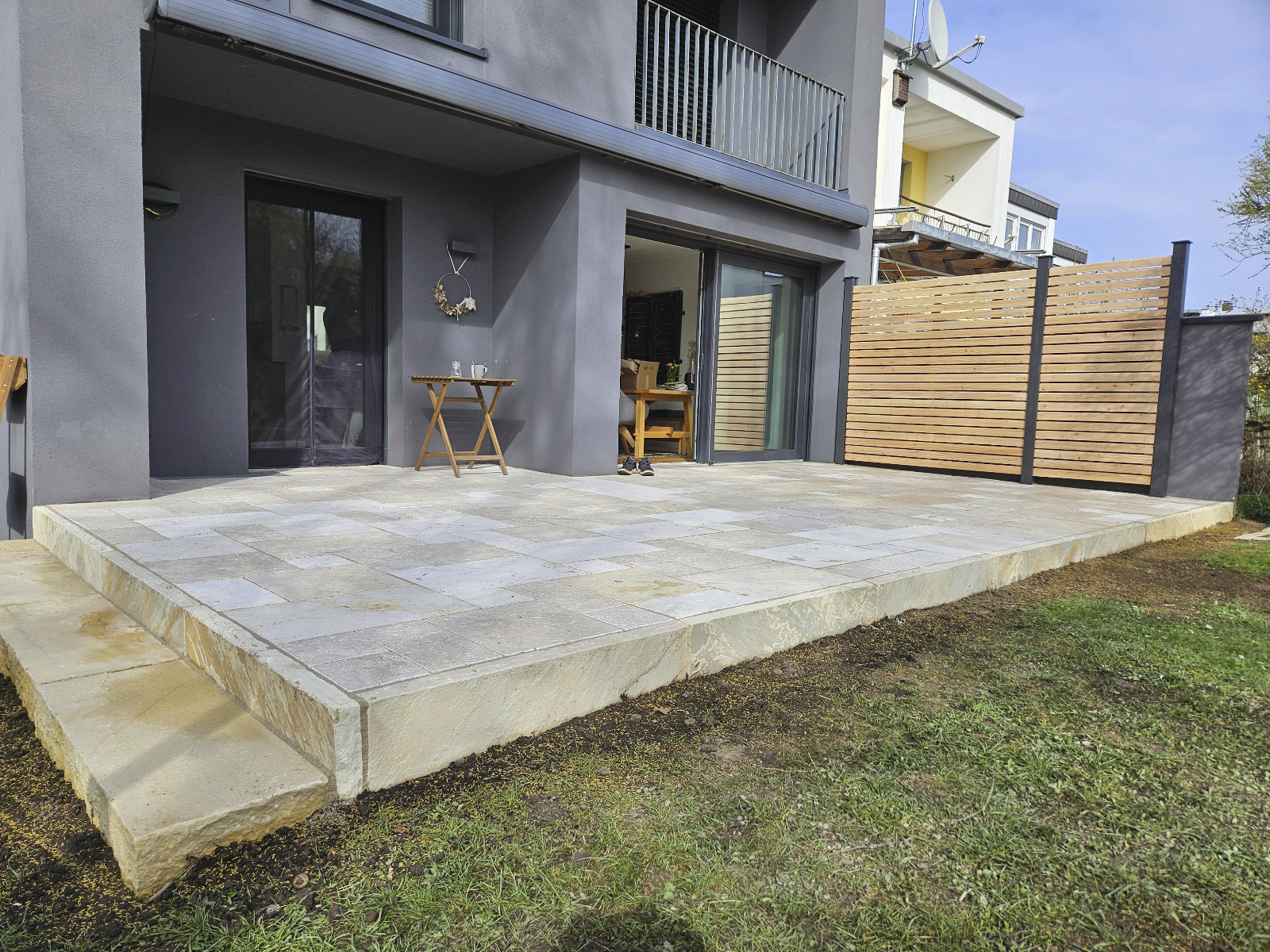 Neue Natursteinterrasse mit Holz-Sichtschutz – Gartengestaltung von AN Garten- und Landschaftsbau